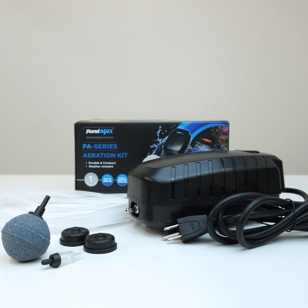 PondMAX PA7 aeration kit contents in front of its box: single-outlet air pump, one 2-inch sphere air stone, check valve, spare diaphragms and tubing